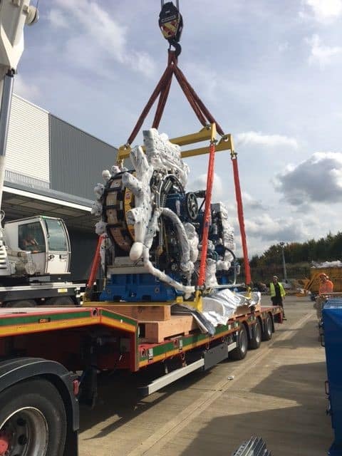 Vanguard Industrial Group crane safely lifting heavy factory machinery on site.