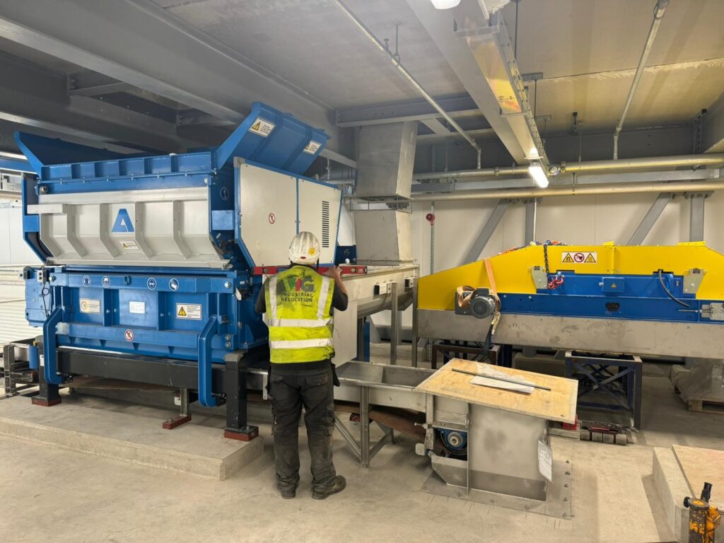 Vanguard Industrial Group operative carefully maneuvering and installing factory machinery.